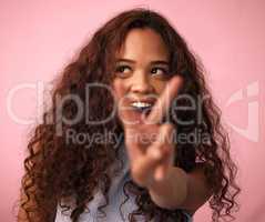 Peace and love is all Im asking for. Studio shot of a beautiful young woman showing the peace sign while standing against a pink background.