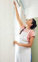 Curtains can change the look of any room. a young woman hanging clean curtains at home.