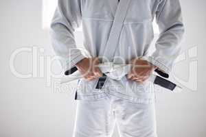 Time to begin. an unrecognizable male martial artist standing with his hands on his belt in the gym.