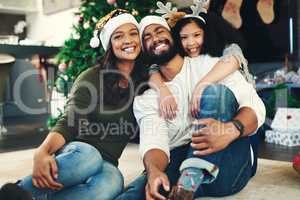 The spirit of Christmas summed up in one moment. Portrait of a happy young family celebrating Christmas at home.