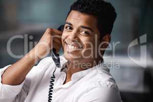 Give me a call and Ill sort you out. Portrait of a young businessman talking on a telephone in an office.