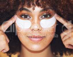 Theres a solution for those fine line. a beautiful young woman wearing under-eye gel patches as part of her skincare routine.