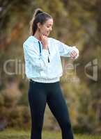 Tracking her intensity during a workout. a sporty young woman checking her pulse while exercising outdoors.