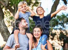 Praise your children openly, reprehend them secretly. Portrait of a beautiful family with their sons on their shoulders in a park.