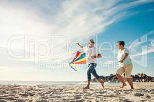 You need to let go of certain things but hold on to fun. a mature couple on the beach with a kite.