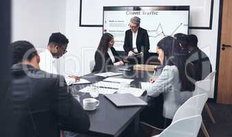 Do you see how it changes if you do this. a mature businesswoman giving a presentation to her staff while using a digital tablet.