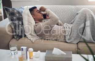 Best to call the doctor if youre feeling ill. a young man talking on a cellphone while feeling sick at home.
