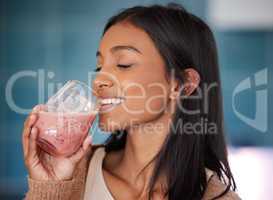 Fresh smoothies nourish your body with many essential vitamins. a young woman drinking a healthy smoothie at home.