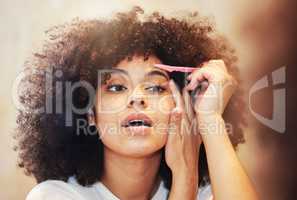 Gotta get these brows on fleek. a beautiful young woman shaping her eyebrows.