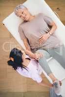 Help others find their center. an older woman doing light exercises during a session with a physiotherapist inside.