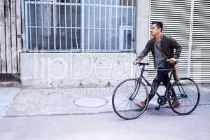 Keeping my commuting eco-friendly. a young man using a bicycle in the city.