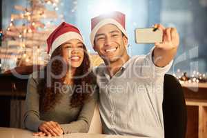 Making memories through all the holidays. two young businesspeople taking a selfie while celebrating Christmas at work.