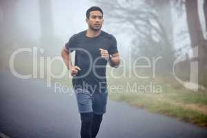 A mighty warrior has appeared from the mist. a sporty young man running outdoors.