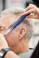 A good haircut will instantly boost your confidence too. a mature man getting a haircut in a salon.