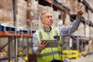 Collecting data on all current stock and merchandise. a mature man using a digital tablet while working in a warehouse.