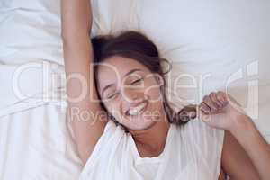I am never embarrassed to relax. a young female waking up in bed at home.