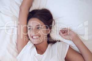 Relax and be mindfully present in the moment. a young female waking up in bed at home.