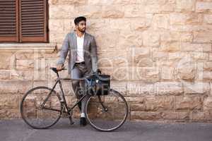 Staying fit and being environmentally friendly at the same time. a young businessman using a bike in the city.