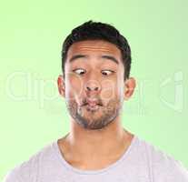 Can you do this. a handsome young man making a face against a green background in studio.