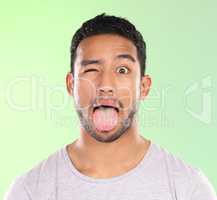 A little quirky. Cropped portrait of a handsome young man making a face against a green background in studio.