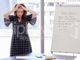 I feel like my head is going to explode. a young businesswoman distressed in her office.