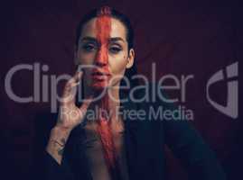 The most courageous act is still to think for yourself. Studio shot of a young woman posing with paint on her face on a black background.