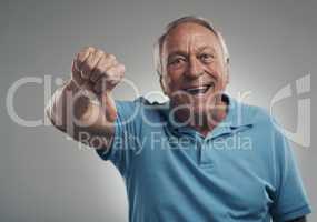 Id give that product a thumbs down definitely. a happy older man giving the thumbs down in a studio against a grey background.