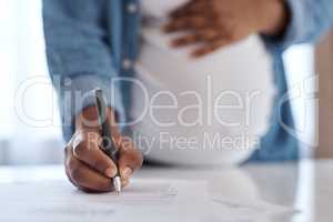 Making sure everything is in order before going into labour. a pregnant woman signing documents.