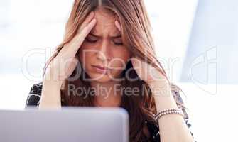 I dont know how Ill get all this work done. a young businesswoman sitting in front of her laptop in distress.