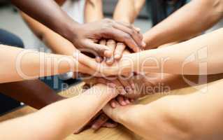 Were stronger as a team. a diverse team of staff piling their hands together.