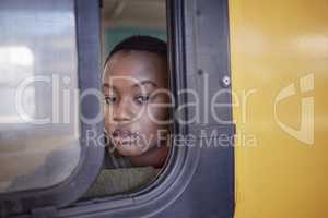 Leaving the past behind. a young woman looking depressed while staring out the window of a train.