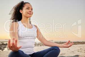 Shes on the path to inner peace. an attractive young woman meditating on the beach.