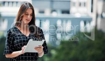 Fresh air brings fresh ideas. a young businesswoman using a tablet against an urban background.