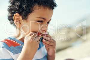 Sunny days and fresh fruits. a young boy enjoying a piece of watermelon outside.