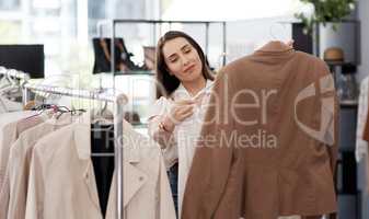 Winter wardrobe loading... a young woman shopping for clothes inside a store.