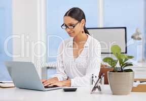 Goal digger. a young businesswoman sitting at a desk using a laptop in a modern office.