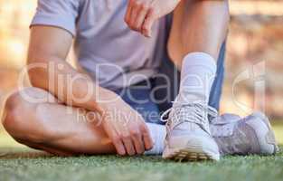 Make sure you get comfortable running shoes. an unrecognizable man tying the laces of his running shoes.