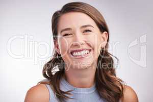 Be your own reason to smile. Studio portrait of a happy young woman posing against a grey background.