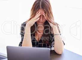 Im so stressed out today. a young businesswoman sitting in front of her laptop in distress.