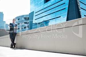 Big dreams and big buildings. a mature businessman standing with his arms crossed in front of a building in the city.