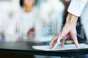 Business person touching report, paper or document while in a meeting, seminar or training at work. Hand of a confident manager, leader or boss doing a presentation in a workshop or conference