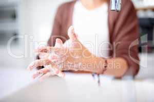 Dont forget to get in between those fingers. an unrecognizable woman washing her hands at home.