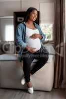 Looking forward to this amazing journey ahead. a pregnant woman looking thoughtful at home.