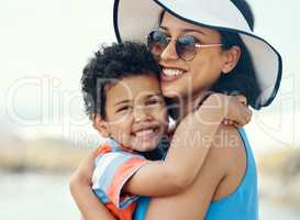 My son is my pride and joy. a mother holding her son at the beach.