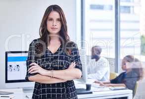 The more confidence you portray, the more successful youll be. Portrait of a young businesswoman standing in an office with her colleagues in the background.