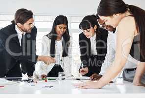 Deciding on who will be in charge of what. a group of businesspeople brainstorming together in an office.