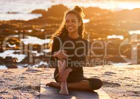 Yoga is the practice of being present in every moment. an attractive young woman sitting on her yoga mat during a yoga session on the beach at sunset.