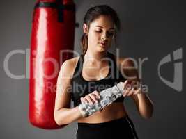 Staying hydrated. an attractive young female boxer drinking water while training in the gym.