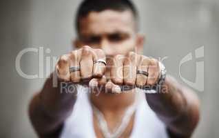 Its a rite of passage. Closeup shot of a male gangsters hands showing off his rings with clenched fists.