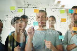Group of creative business people brainstorm ideas on a glass board. Colleagues training, teamwork in a workshop or seminar for learning innovative startup company strategy in a meeting together
